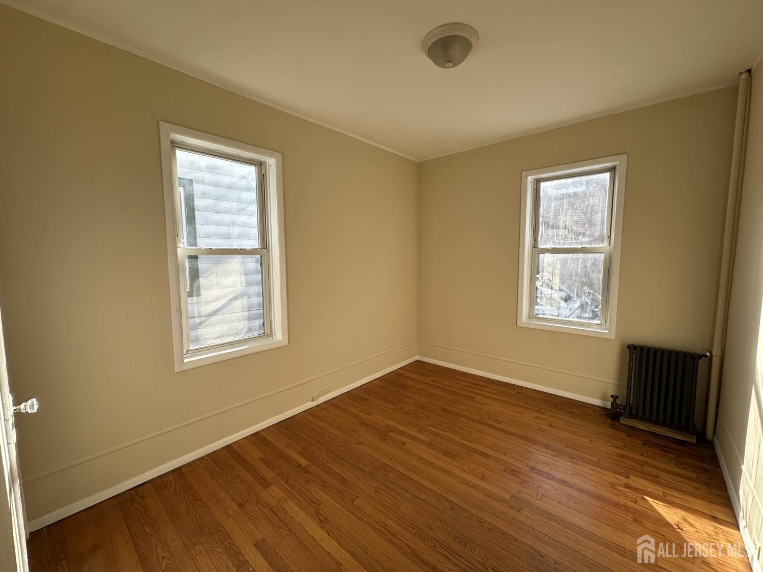 66 Louis Street New Brunswick, NJ 08901 - Photo 8 of 10 a view of an empty room with wooden floor and a window