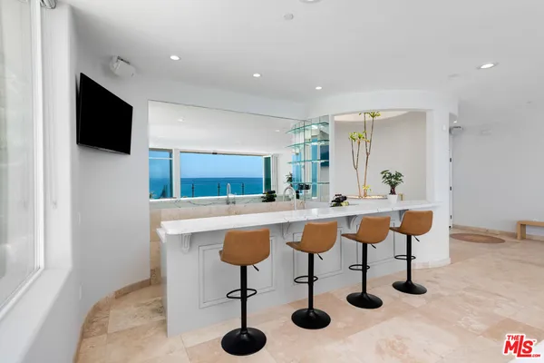 a view of kitchen island with stainless steel appliances kitchen island sink refrigerator and dining table
