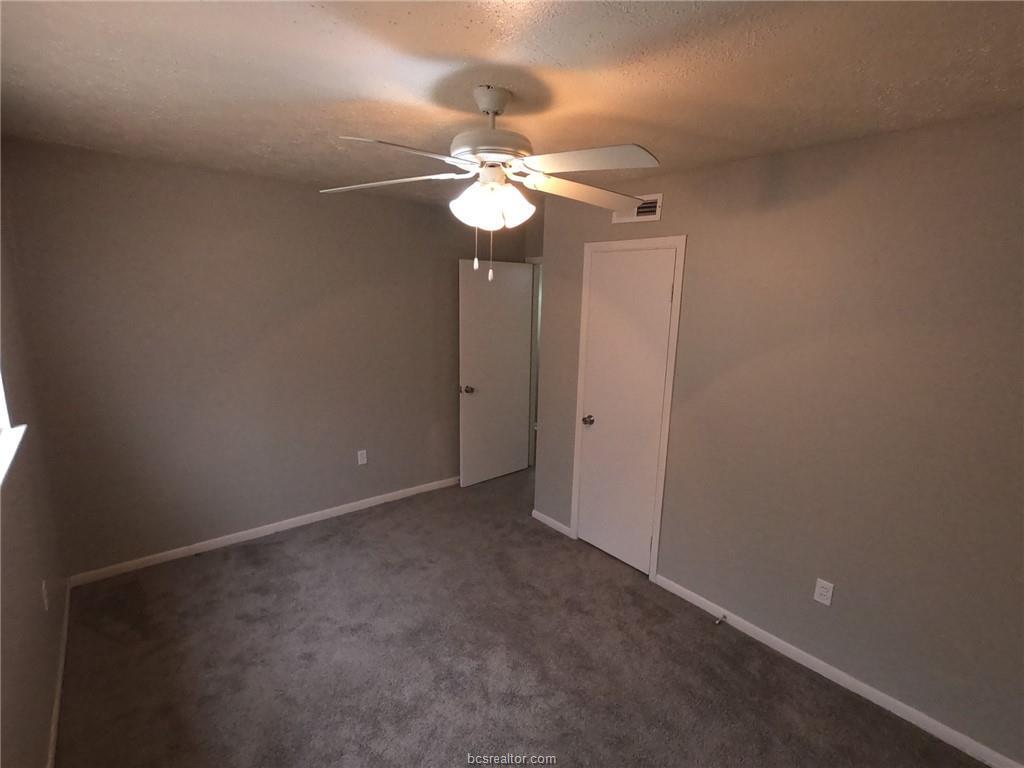 3300 South College Avenue, Unit A05 Bryan, TX 77801 - Photo 12 of 15 an empty room with a fan and a fan