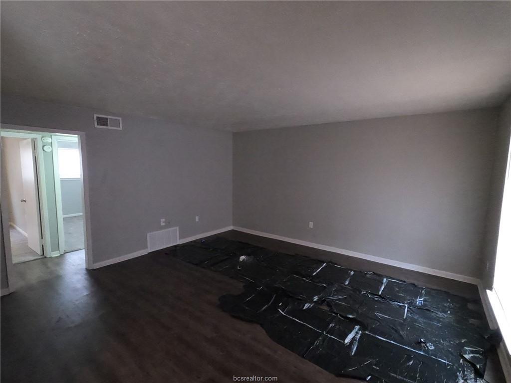 3300 South College Avenue, Unit A05 Bryan, TX 77801 - Photo 2 of 15 an empty room with wooden floor
