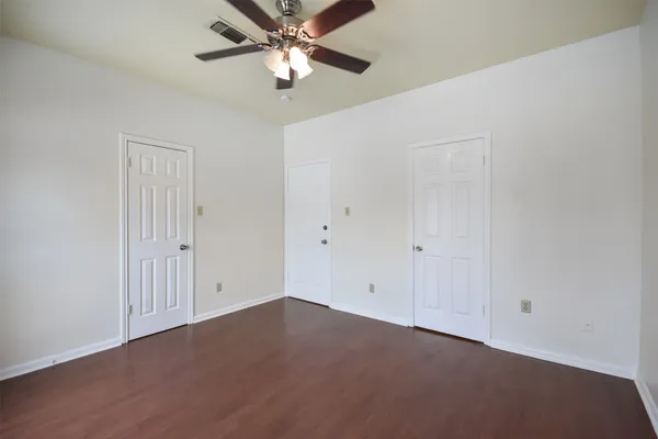 an empty room with a ceiling fan and closet area