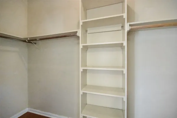a view of walk in closet with empty racks