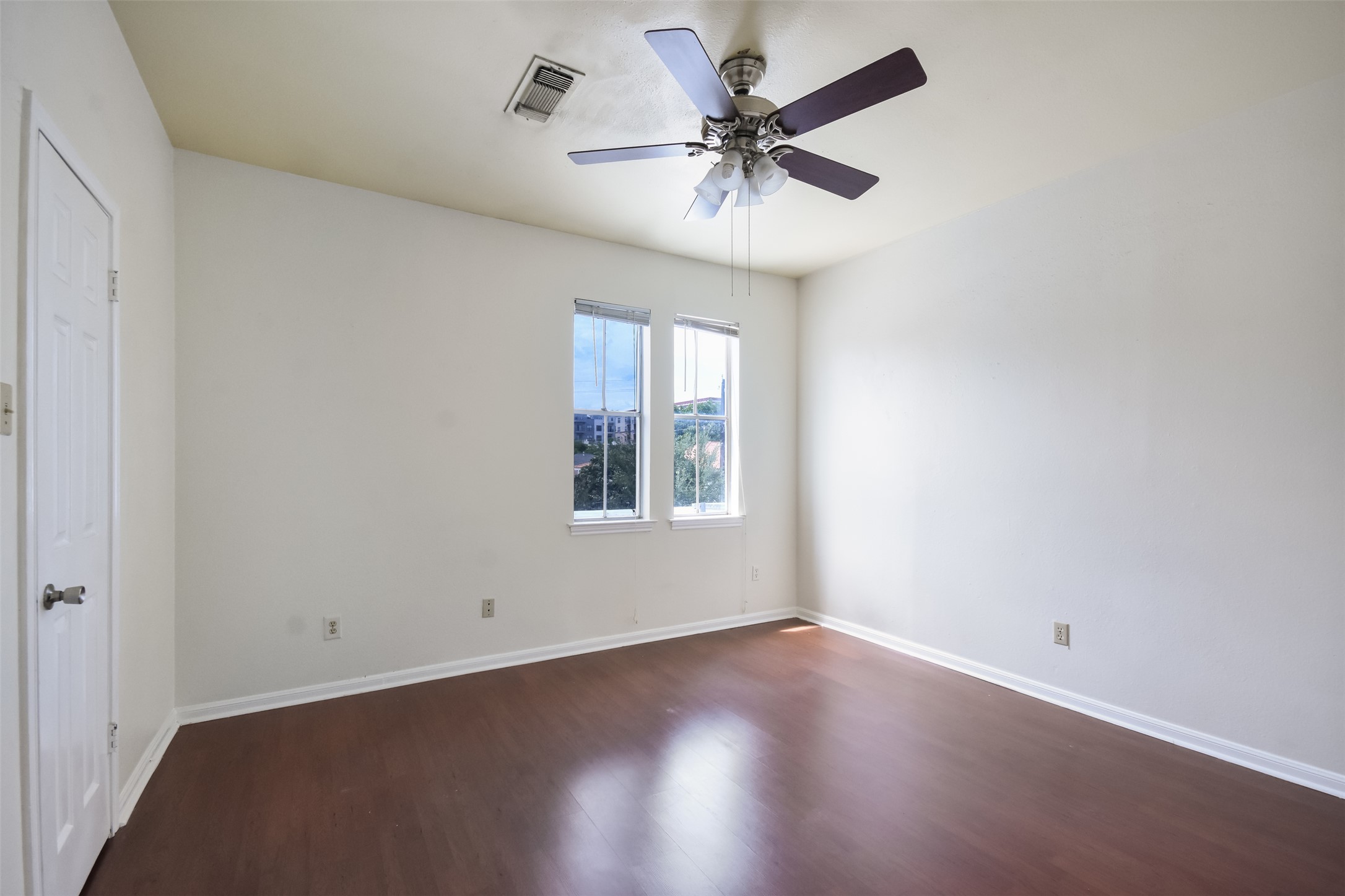 2529 Rio Grande Street, Unit 85 Austin, TX 78705 - Photo 20 of 31 an empty room with wooden floor and windows