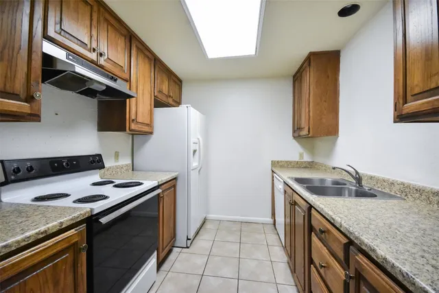 a kitchen with stainless steel appliances granite countertop a sink and a refrigerator
