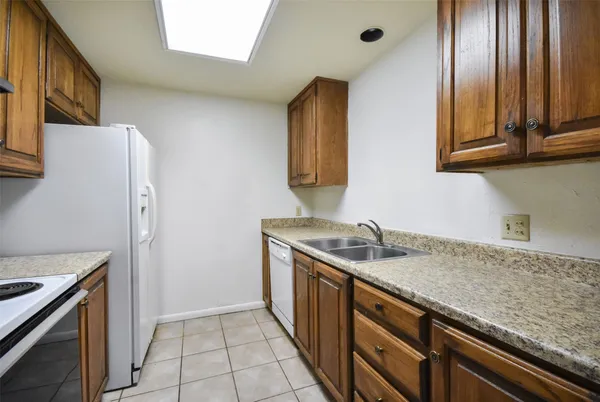 a kitchen with stainless steel appliances granite countertop a sink and a refrigerator