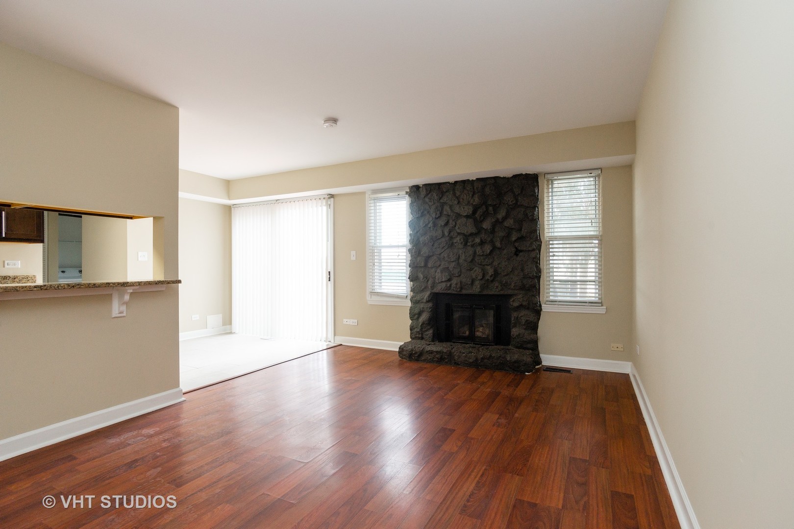 798 Roosevelt Road, Unit 1 Hanover Park, IL 60133 - Photo 2 of 10 a view of empty room with wooden floor and fireplace