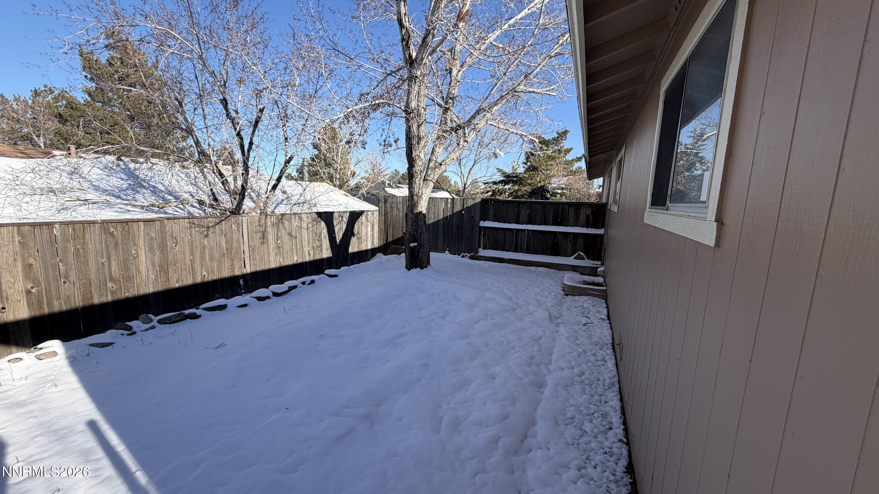 6451 Flower Street Reno, NV 89506 - Photo 14 of 14 a backyard of a house with wooden fence and trees