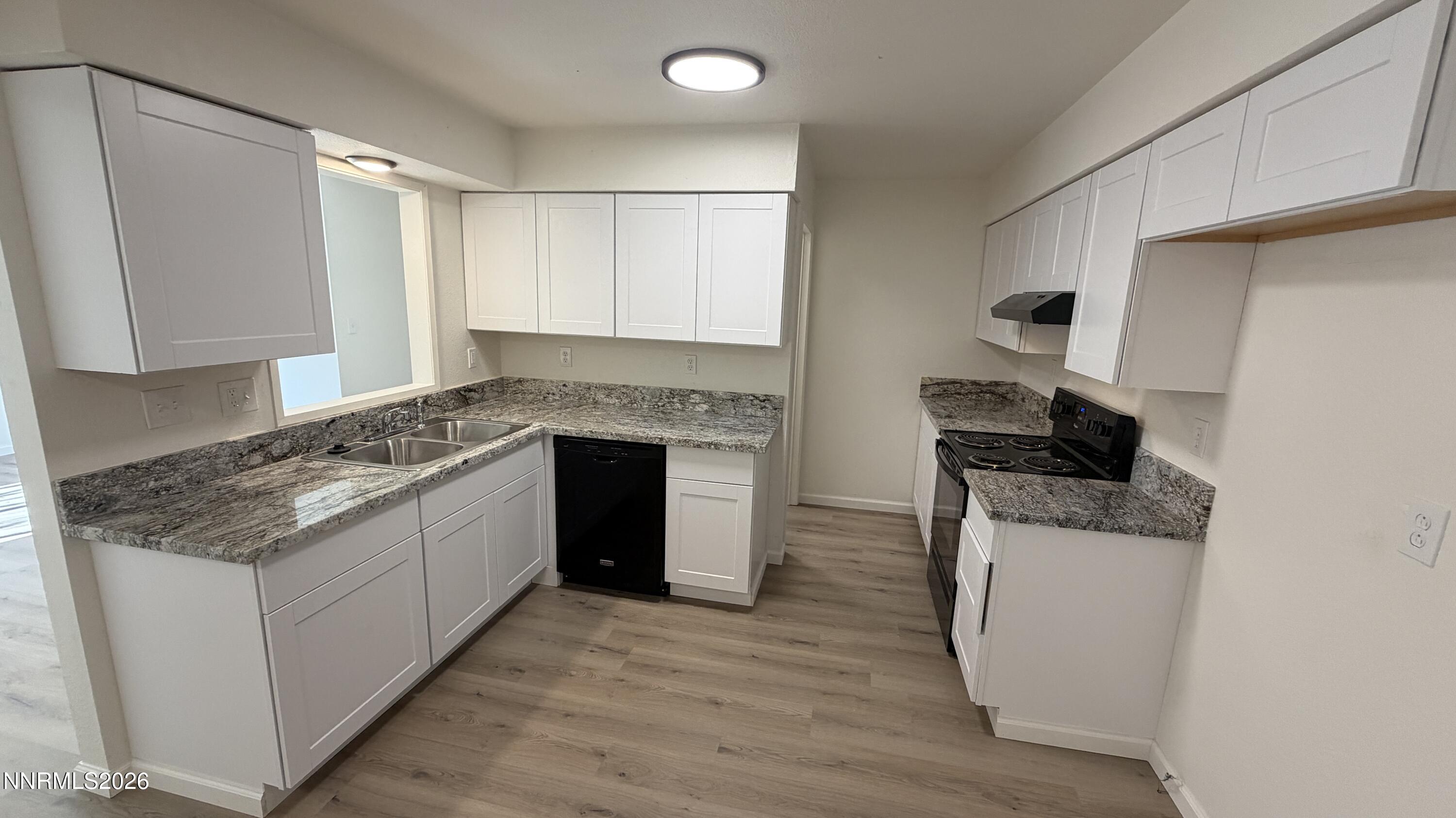 6451 Flower Street Reno, NV 89506 - Photo 4 of 14 a kitchen with granite countertop a sink stove and refrigerator