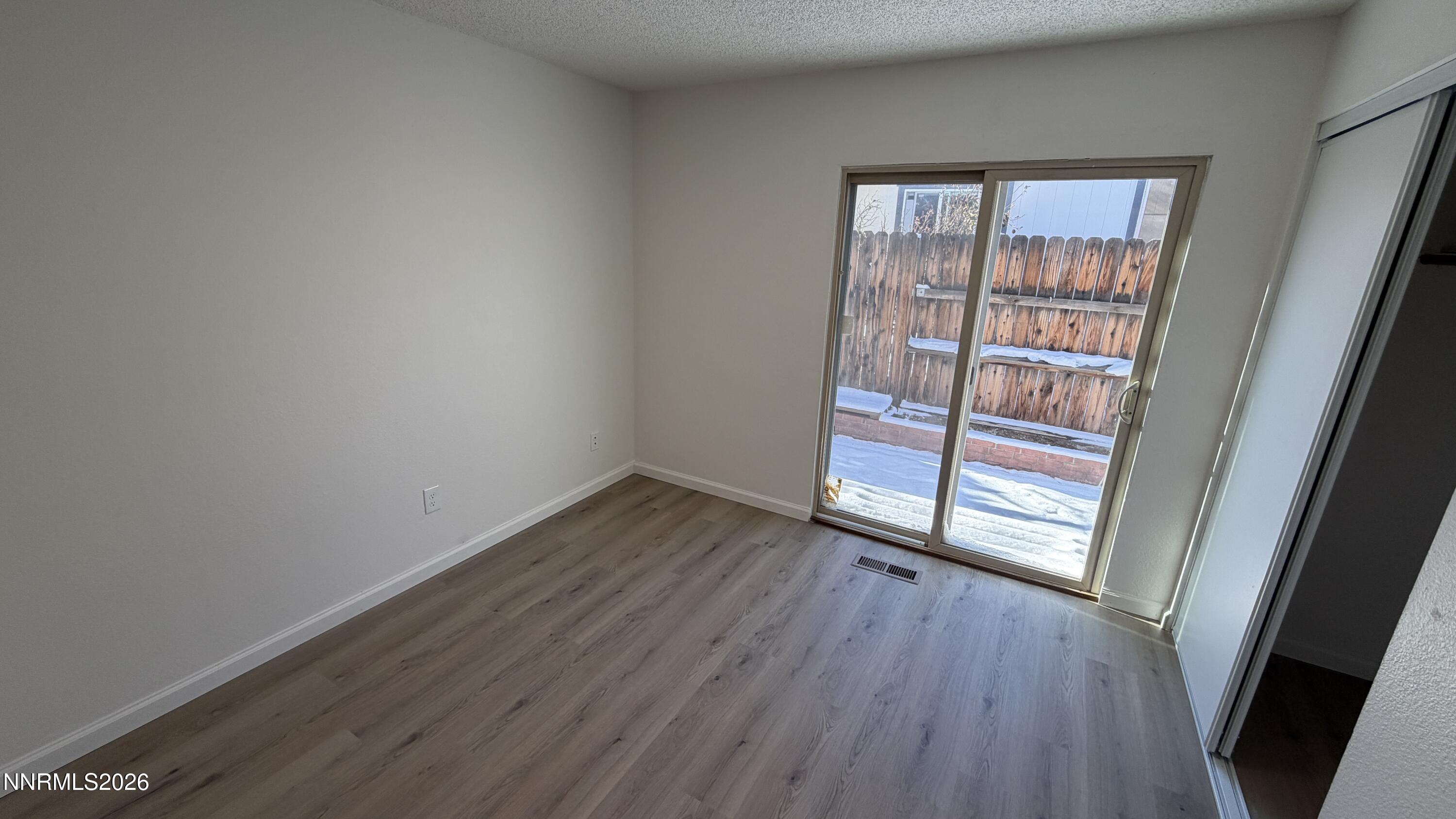 6451 Flower Street Reno, NV 89506 - Photo 9 of 14 an empty room with wooden floor and door