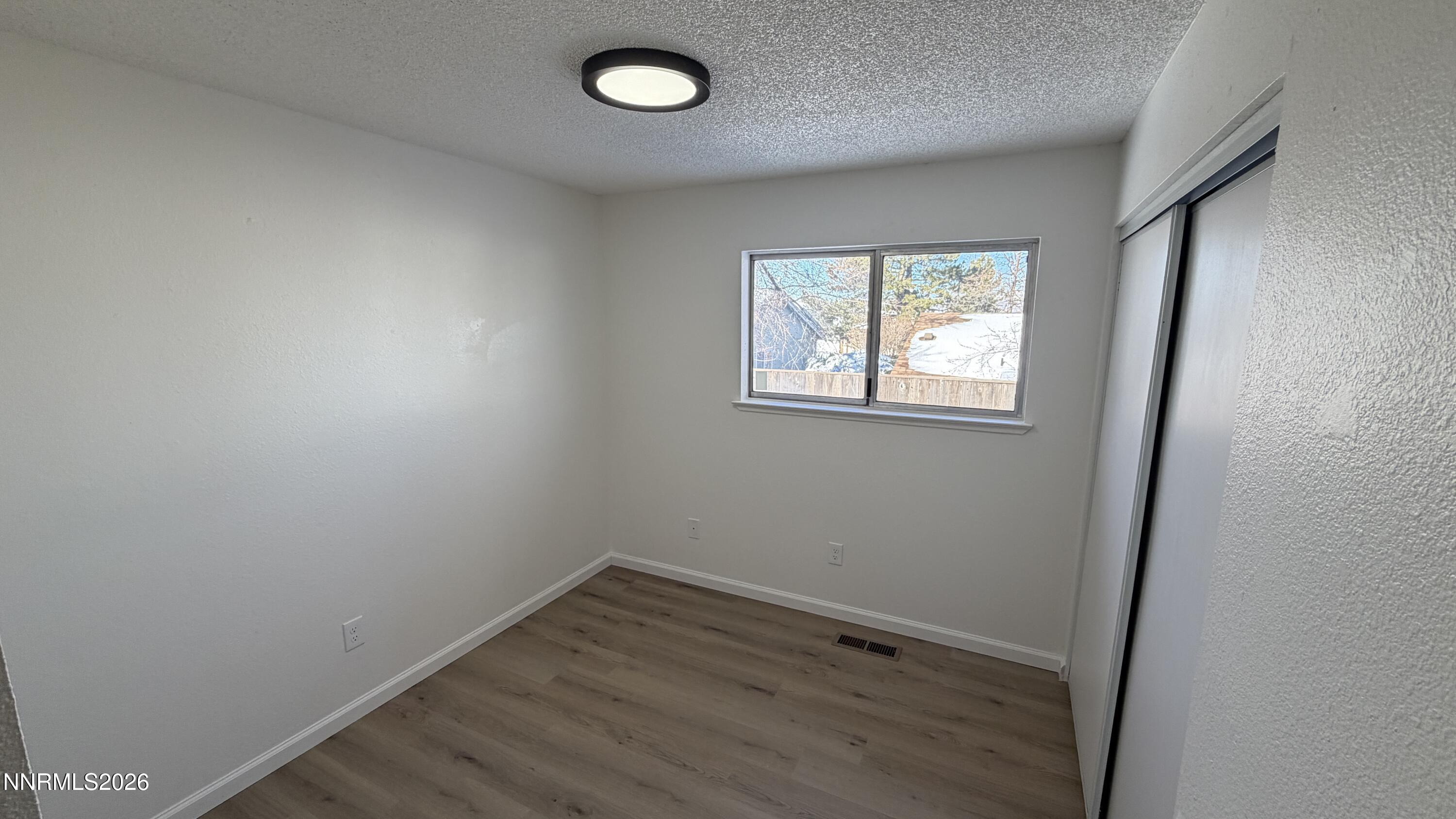 6451 Flower Street Reno, NV 89506 - Photo 10 of 14 an empty room with wooden floor and windows