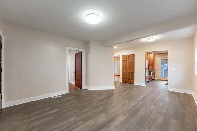 a view of an empty room with wooden floor