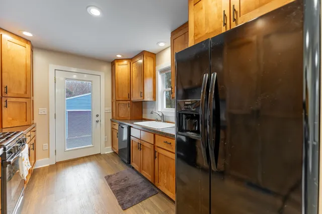 a kitchen with stainless steel appliances granite countertop a refrigerator and a stove