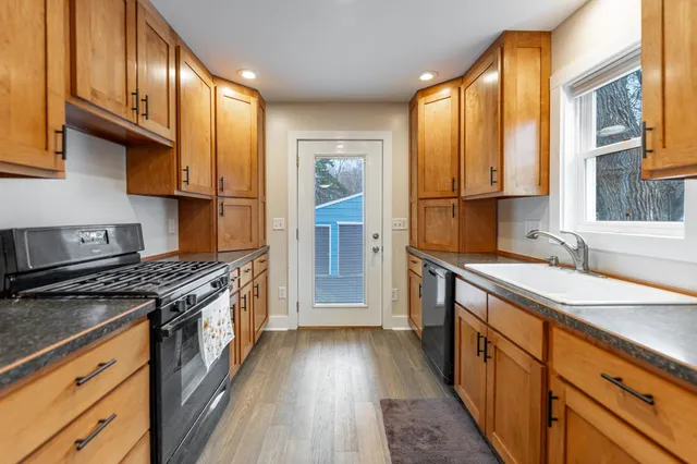 a kitchen with stainless steel appliances granite countertop a stove a sink and a refrigerator