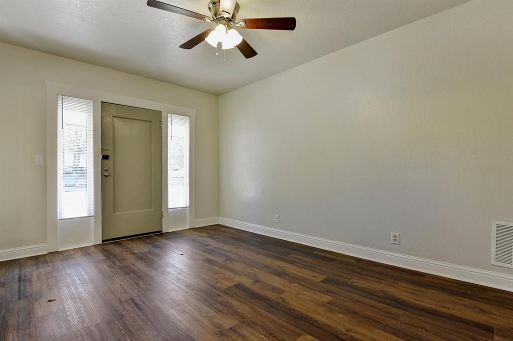 1115 South Rusk Avenue Denison, TX 75020 - Photo 5 of 21 a view of an empty room with wooden floor and a window