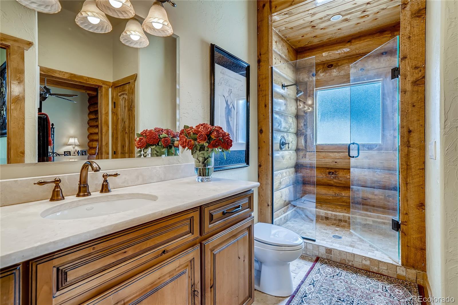 11200 Shimley Road Golden, CO 80403 - Photo 16 of 40 a bathroom with a granite countertop sink mirror vanity and toilet