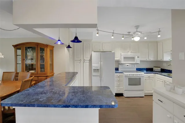 a kitchen with white cabinets and refrigerator