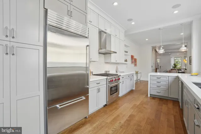 a kitchen with stainless steel appliances a refrigerator sink and white cabinets