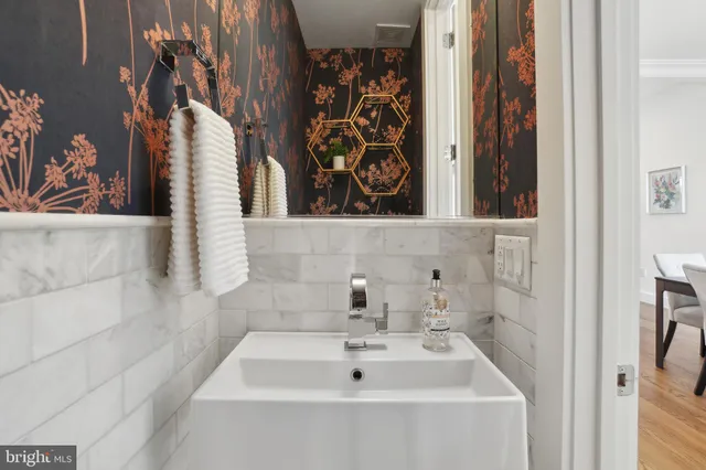 a bathroom with a sink and mirror with bathtub