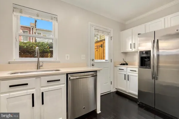 a kitchen with white cabinets and white appliances