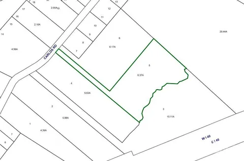 a view of dirt road with a building in the background