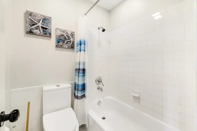 a white toilet sitting next to a bath tub