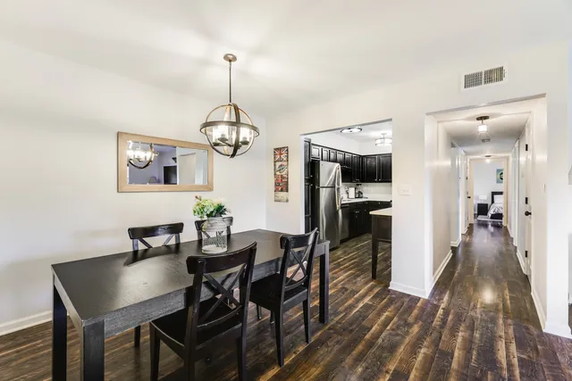 a view of a dining room with furniture wooden floor and chandelier