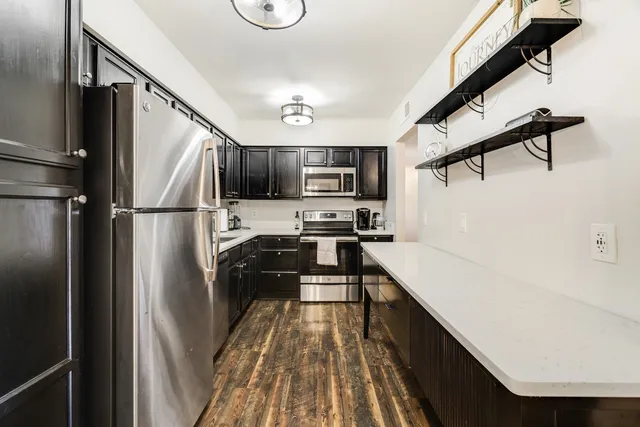 a kitchen with stainless steel appliances a refrigerator and a stove top oven