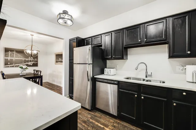 a kitchen with stainless steel appliances a sink cabinets and refrigerator