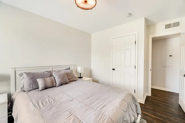 a bedroom with a bed and wooden floor