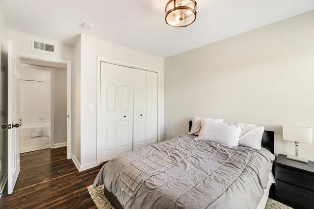 a bedroom with a bed and wooden floor