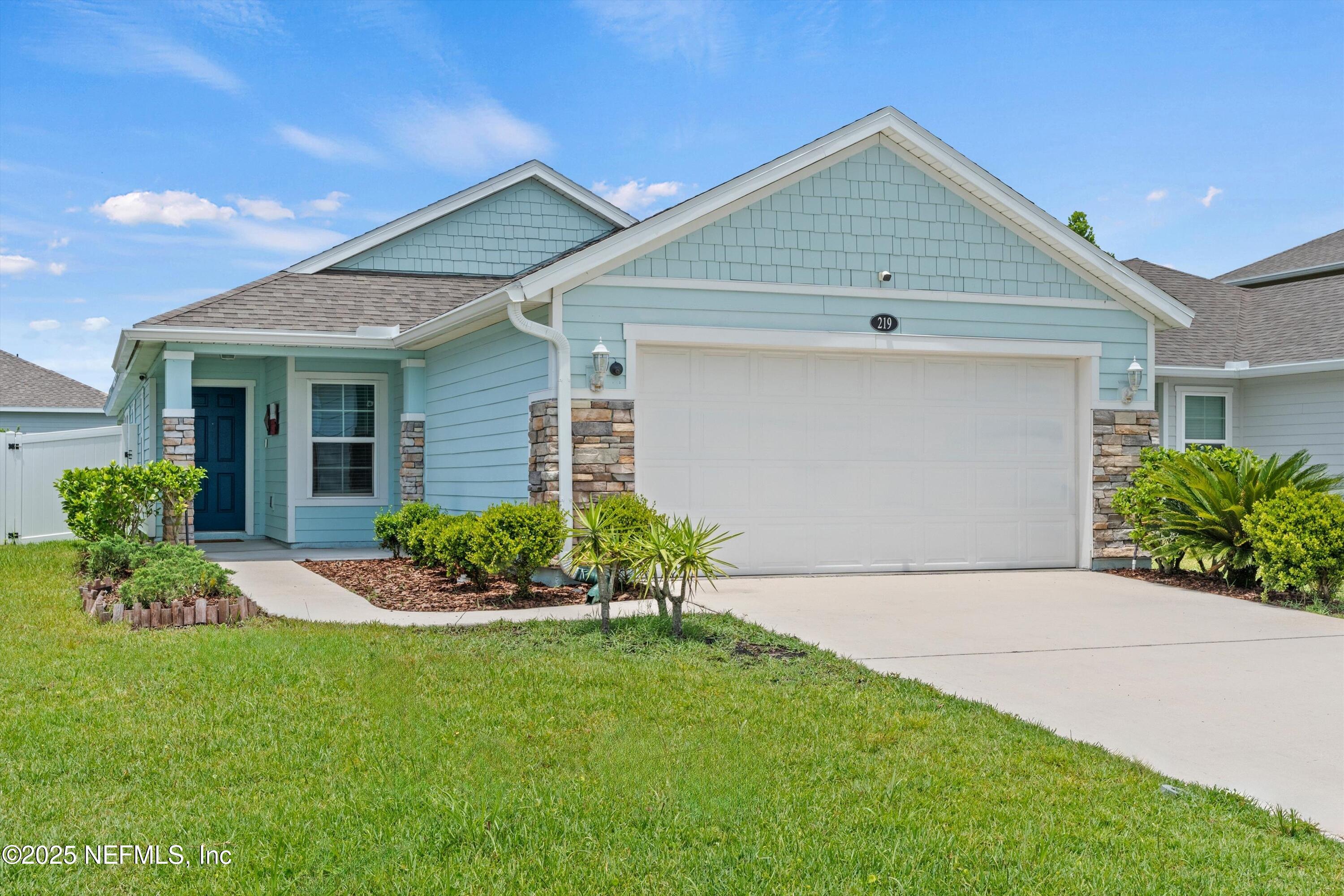 219 Bluejack Lane St. Augustine, FL 32095 - Photo 1 of 44 a front view of a house with a garden and plants