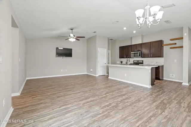 a view of kitchen with granite countertop cabinets and refrigerator