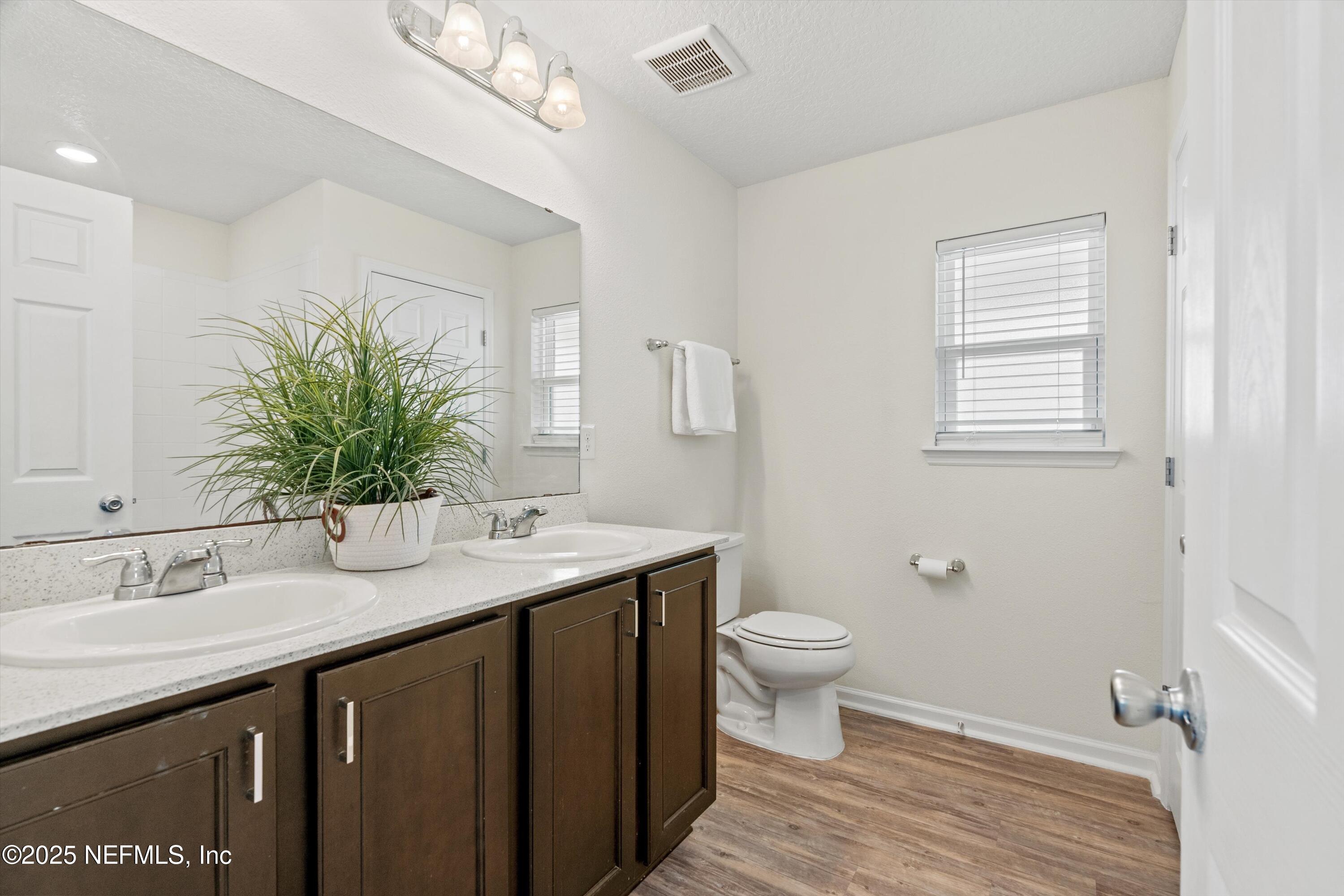 219 Bluejack Lane St. Augustine, FL 32095 - Photo 20 of 44 a bathroom with a granite countertop sink a toilet and a mirror