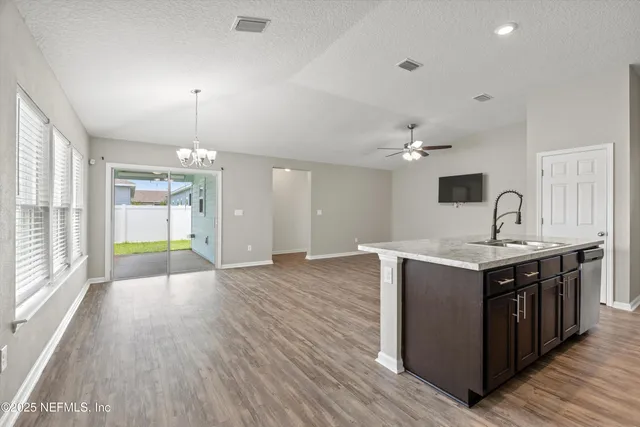 a kitchen with stove and wooden floor