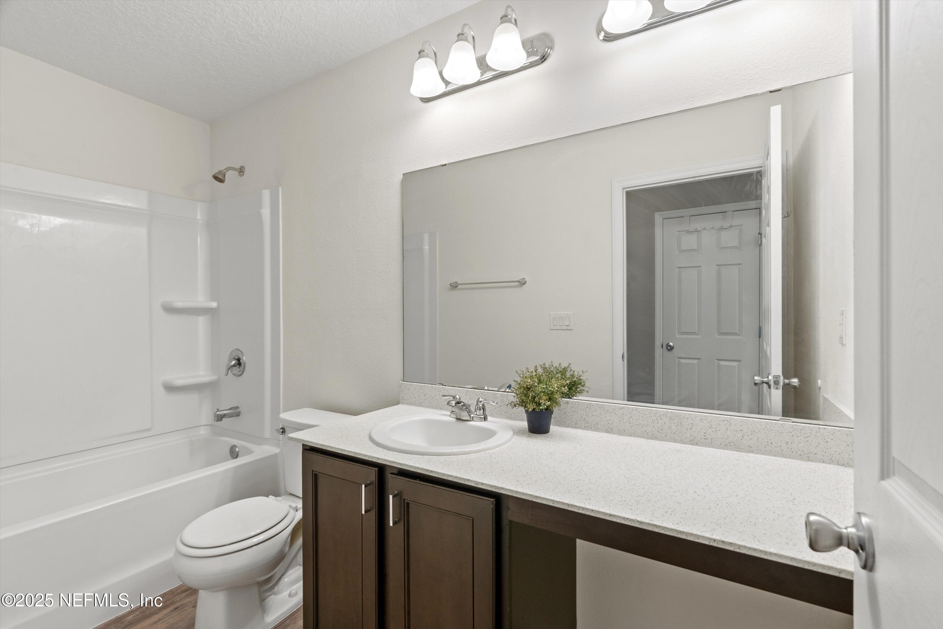 219 Bluejack Lane St. Augustine, FL 32095 - Photo 25 of 45 a bathroom with a sink a toilet a mirror and shower