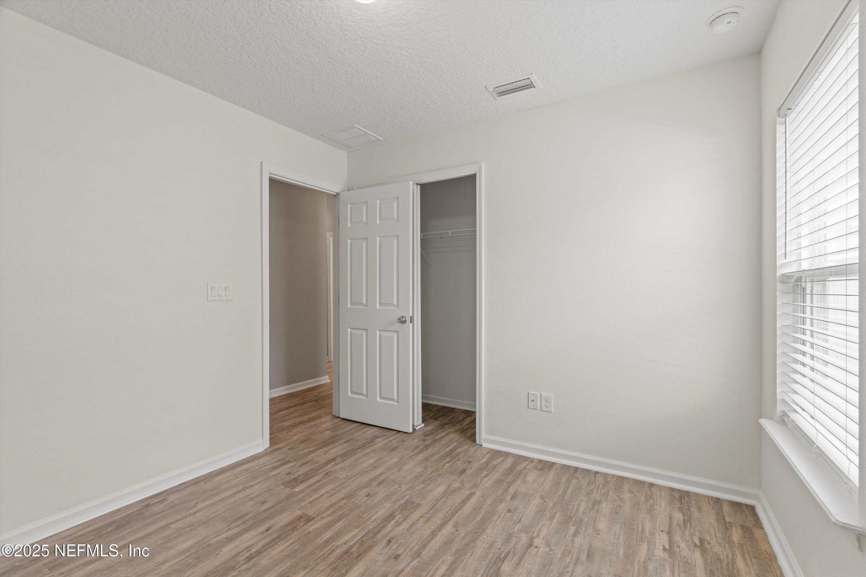 219 Bluejack Lane St. Augustine, FL 32095 - Photo 26 of 44 an empty room with wooden floor and windows
