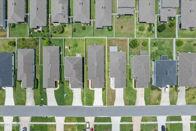 a view of a house with a big yard and large trees