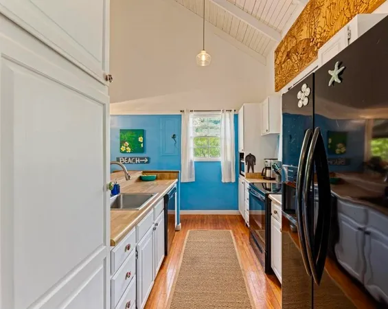 a kitchen with stainless steel appliances a stove a refrigerator a sink a stove and cabinets