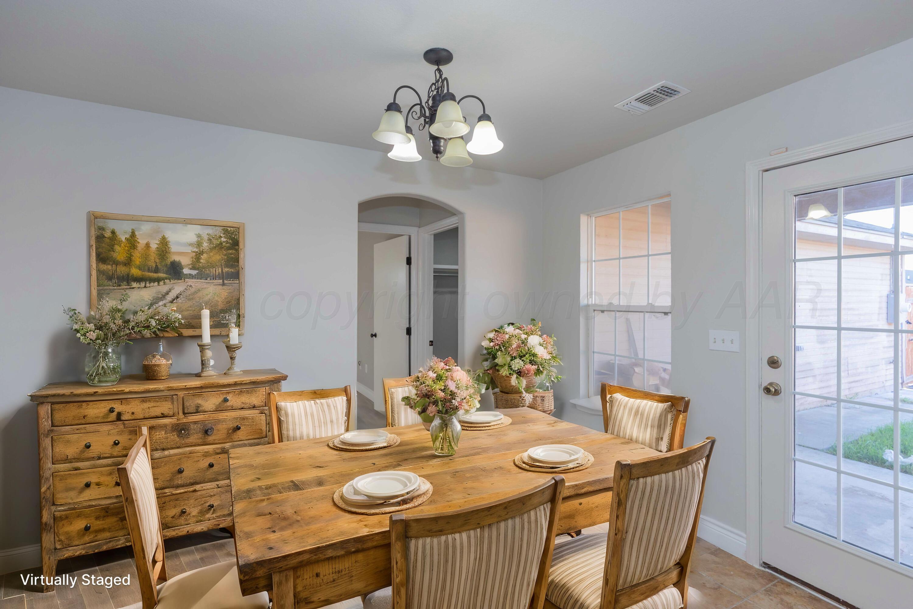 2805 Ries Lane Amarillo, TX 79118 - Photo 12 of 38 a dining room with furniture a chandelier and wooden floor