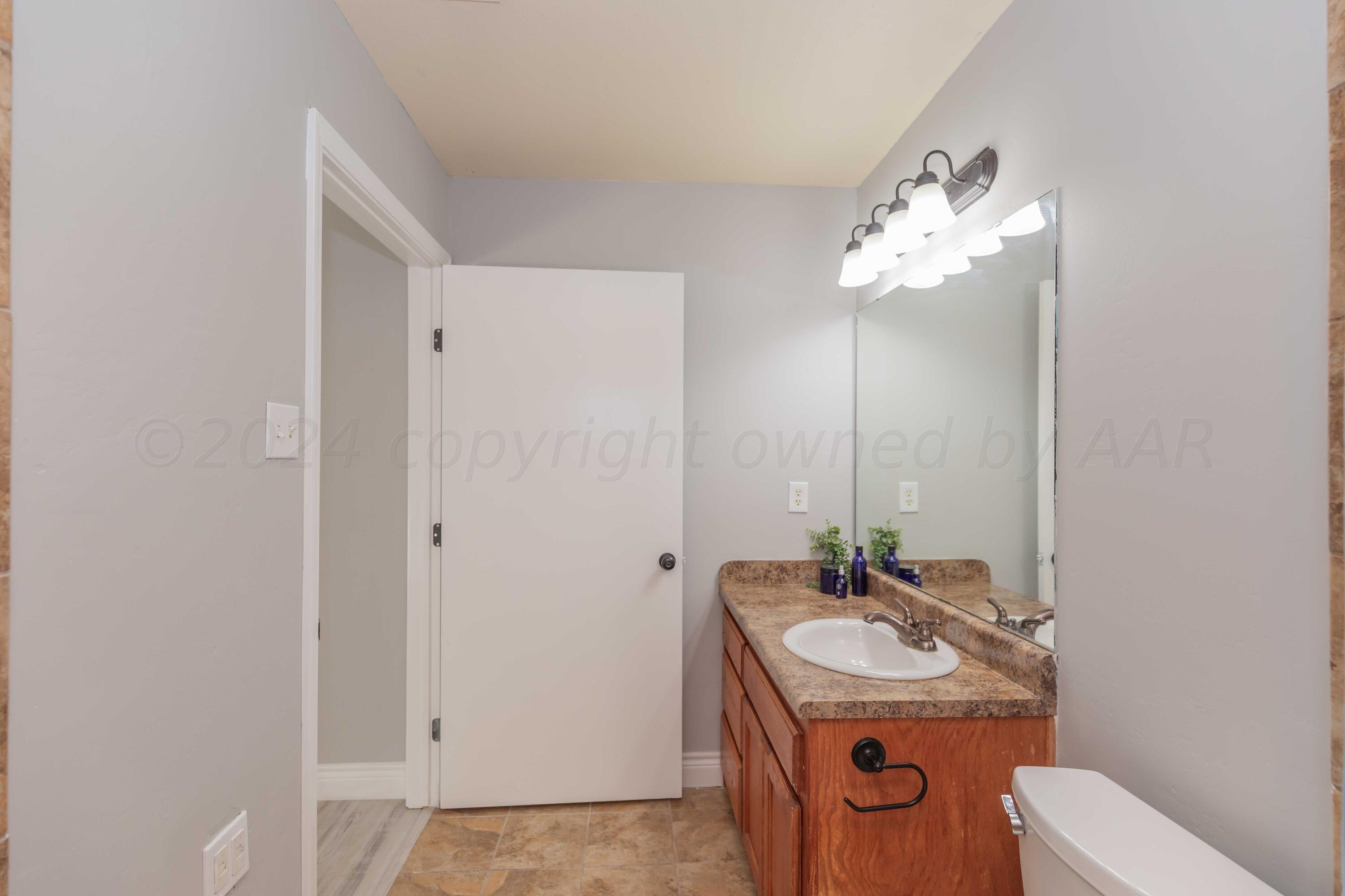 2805 Ries Lane Amarillo, TX 79118 - Photo 19 of 38 a bathroom with a sink a toilet and mirror