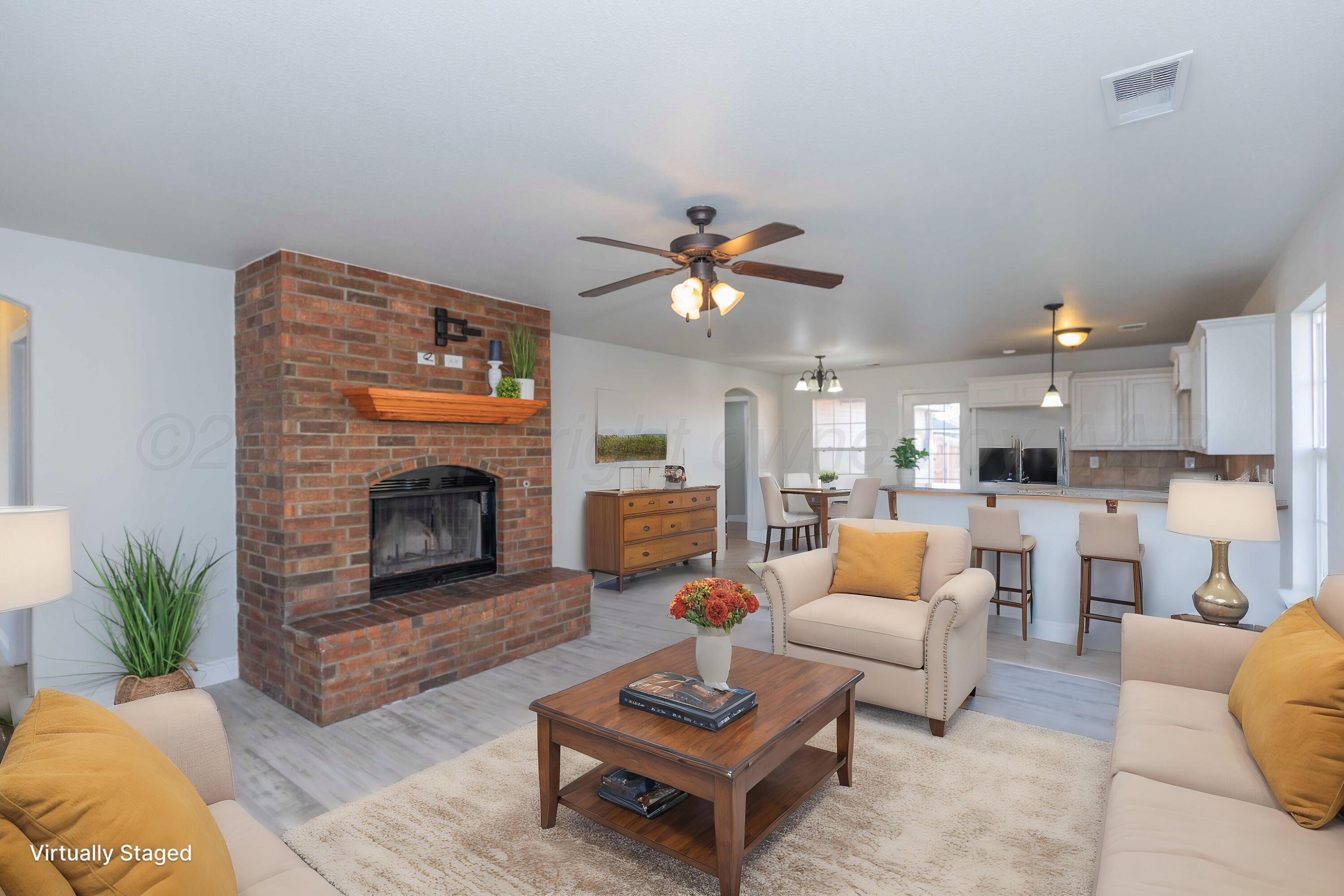 2805 Ries Lane Amarillo, TX 79118 - Photo 2 of 38 a living room with furniture a fireplace and a chandelier