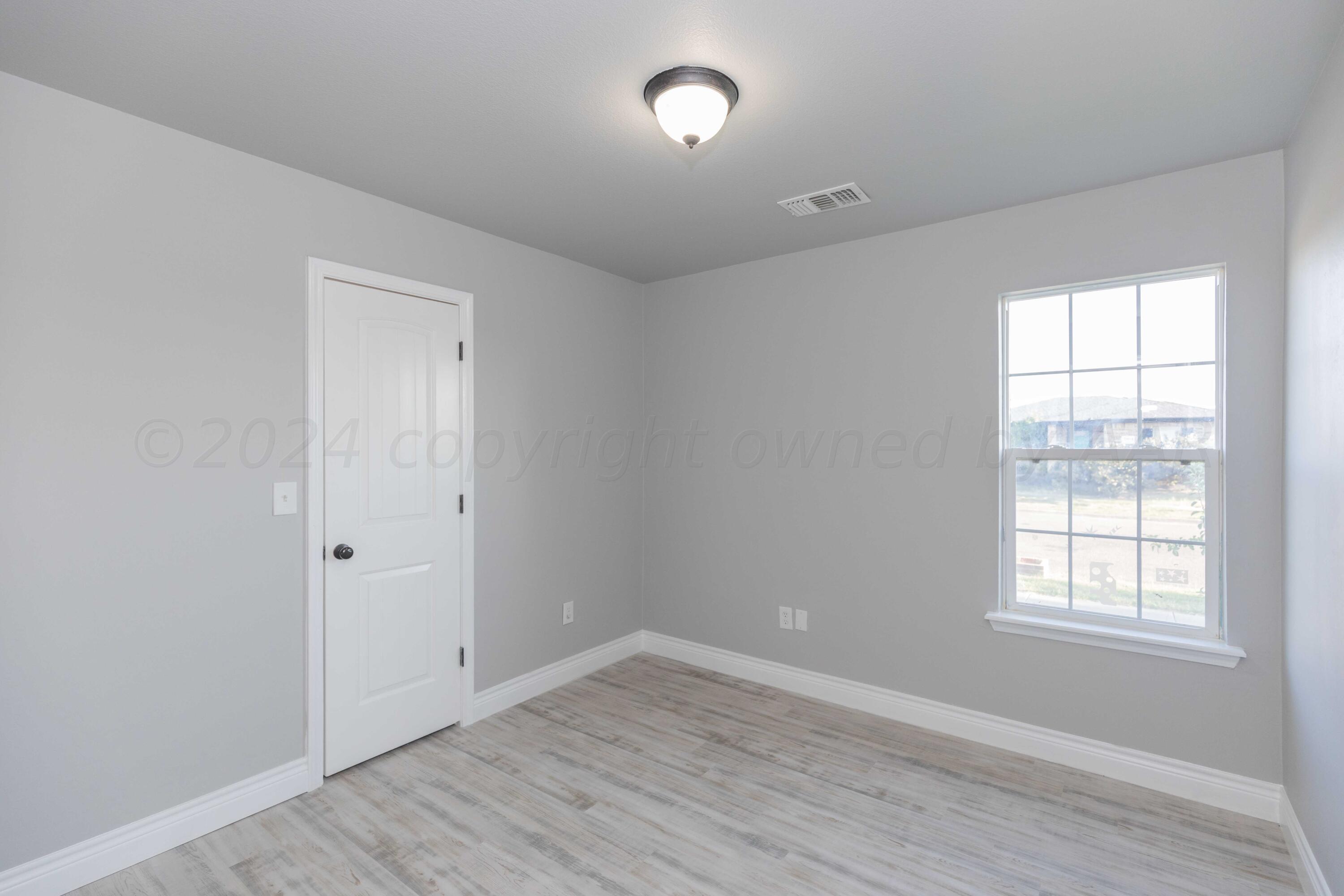 2805 Ries Lane Amarillo, TX 79118 - Photo 23 of 38 an empty room with wooden floor and windows