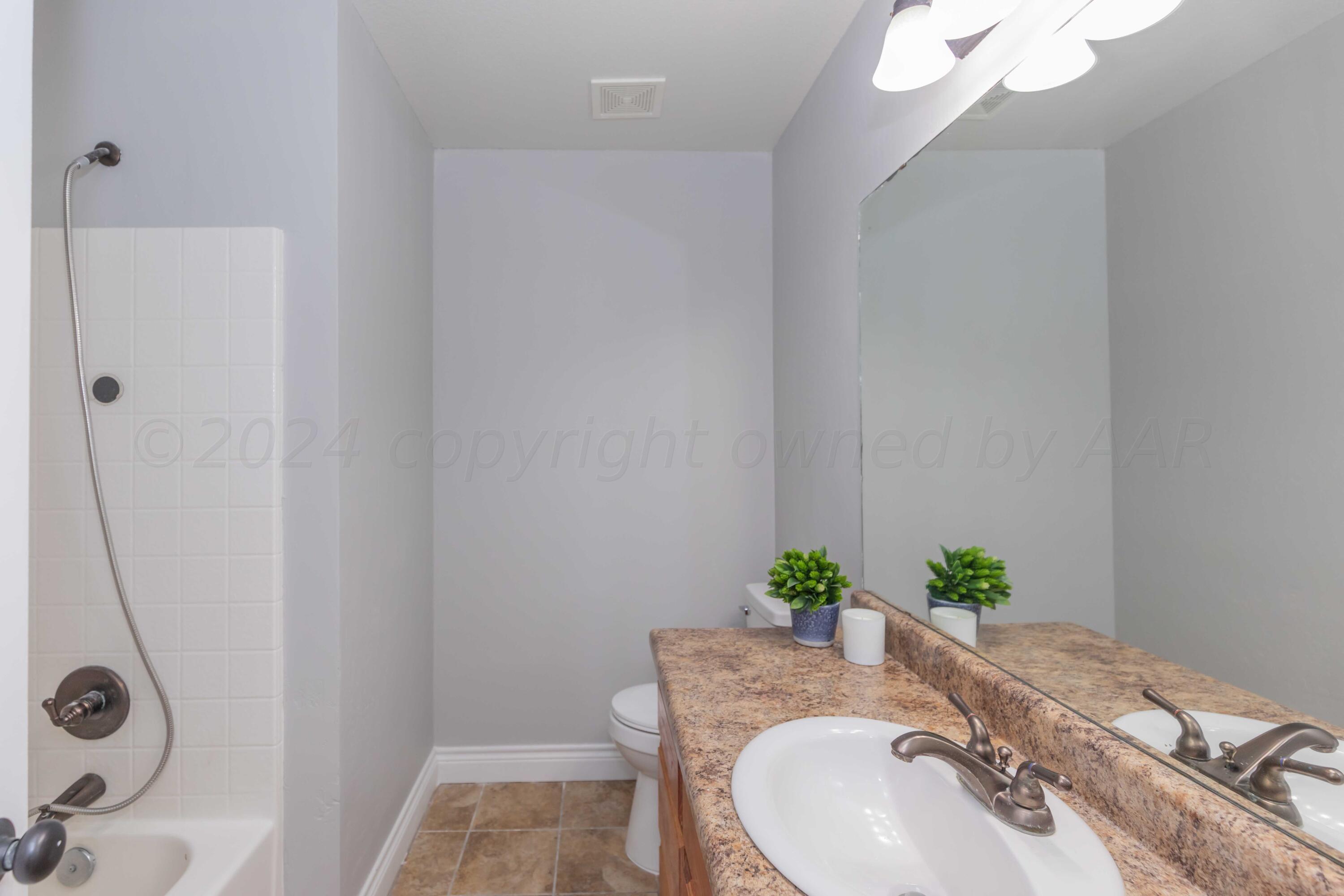 2805 Ries Lane Amarillo, TX 79118 - Photo 25 of 38 a bath room with a granite countertop sink and a mirror