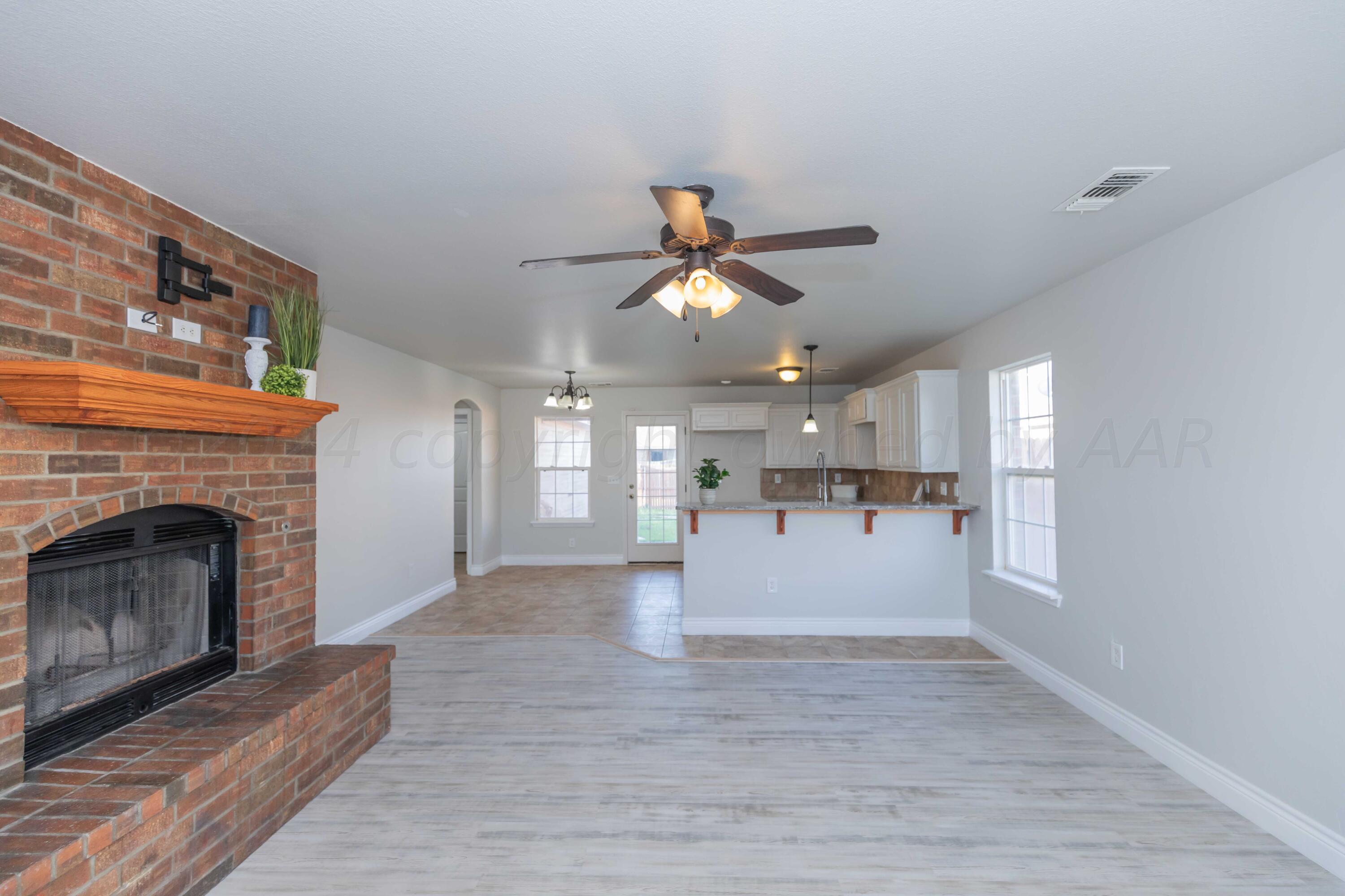 2805 Ries Lane Amarillo, TX 79118 - Photo 4 of 38 a view of an empty room with kitchen and fireplace