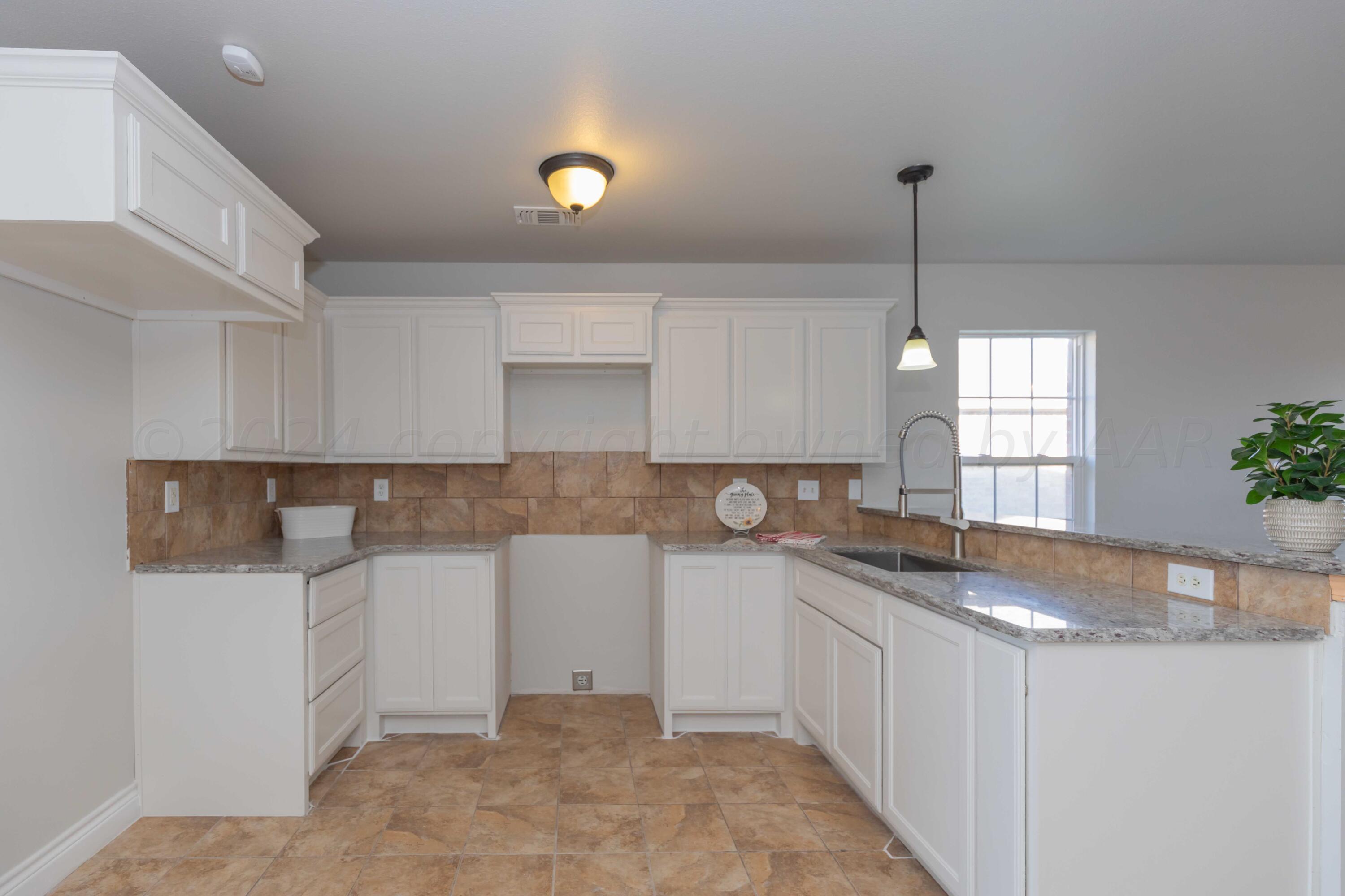 2805 Ries Lane Amarillo, TX 79118 - Photo 8 of 38 a kitchen with stainless steel appliances granite countertop a sink stove and white cabinets