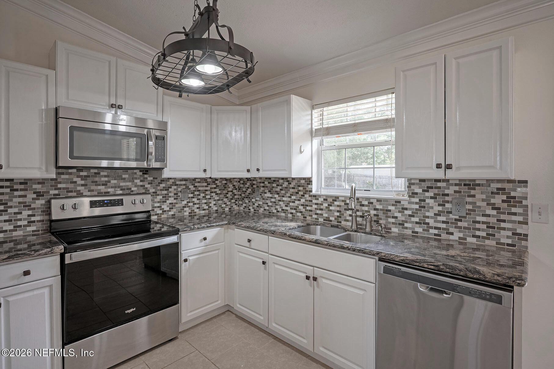 430 Southwest Jasmine Avenue Keystone Heights, FL 32656 - Photo 12 of 35 a kitchen with granite countertop white cabinets stainless steel appliances a sink and a window