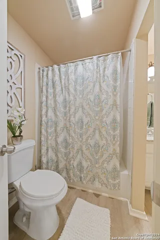 a bathroom with a toilet and a shower curtain