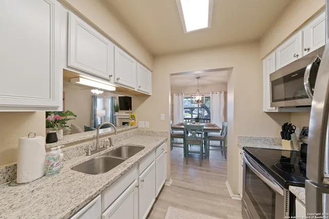 a kitchen with granite countertop a sink and a stove top oven
