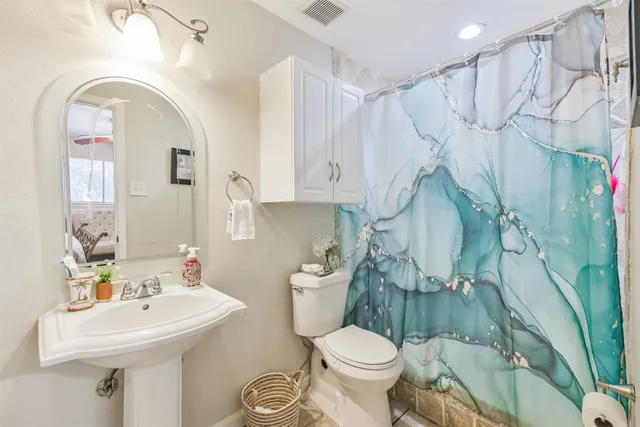 a bathroom with a sink a toilet and a mirror