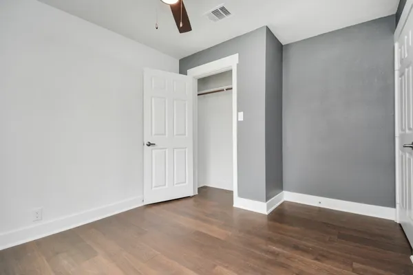 a view of an empty room with wooden floor